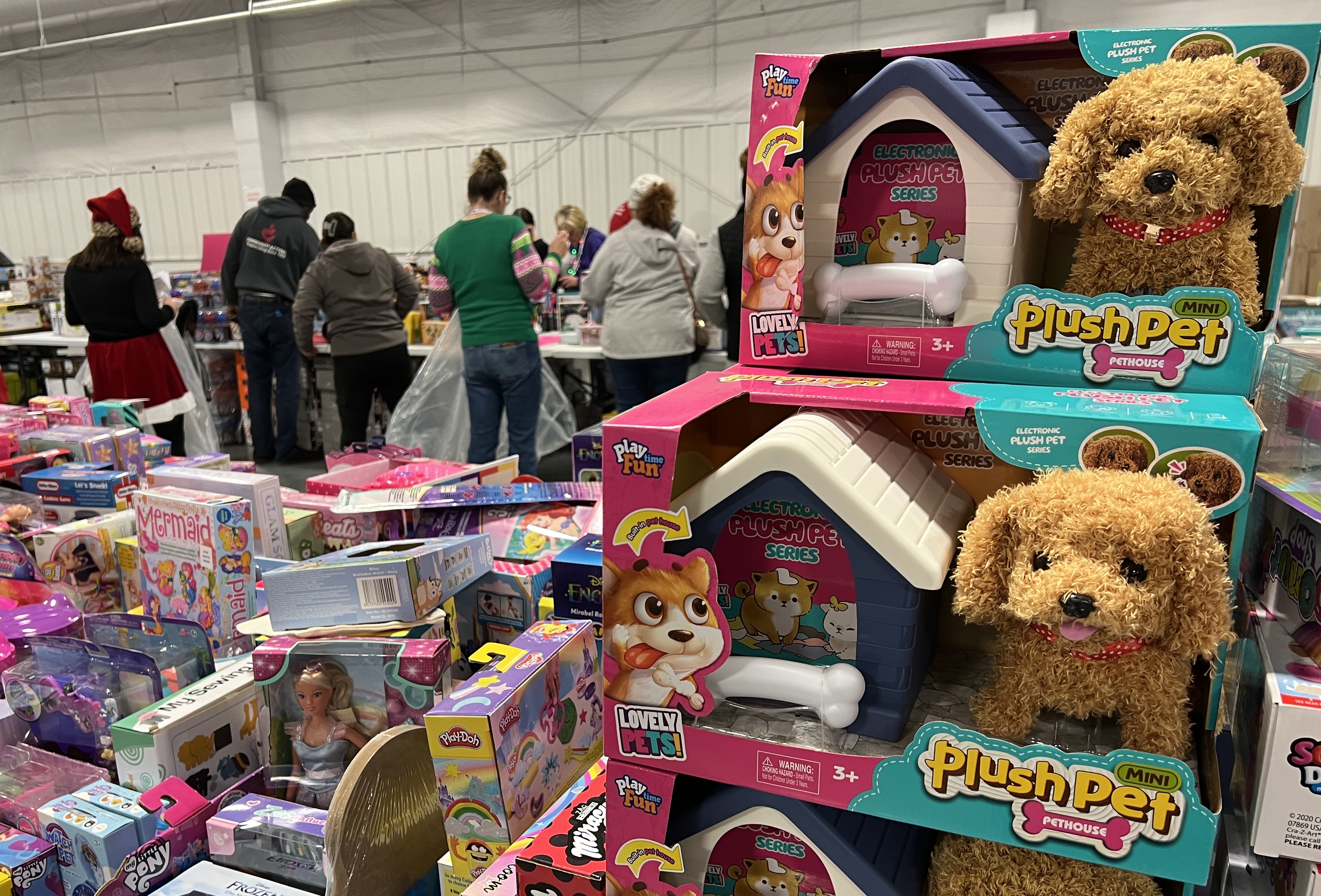 A Plush Pet puppy toy can be seen as parents pick out toys from piles during the 2024 Heartland United Way Toy Distribution.