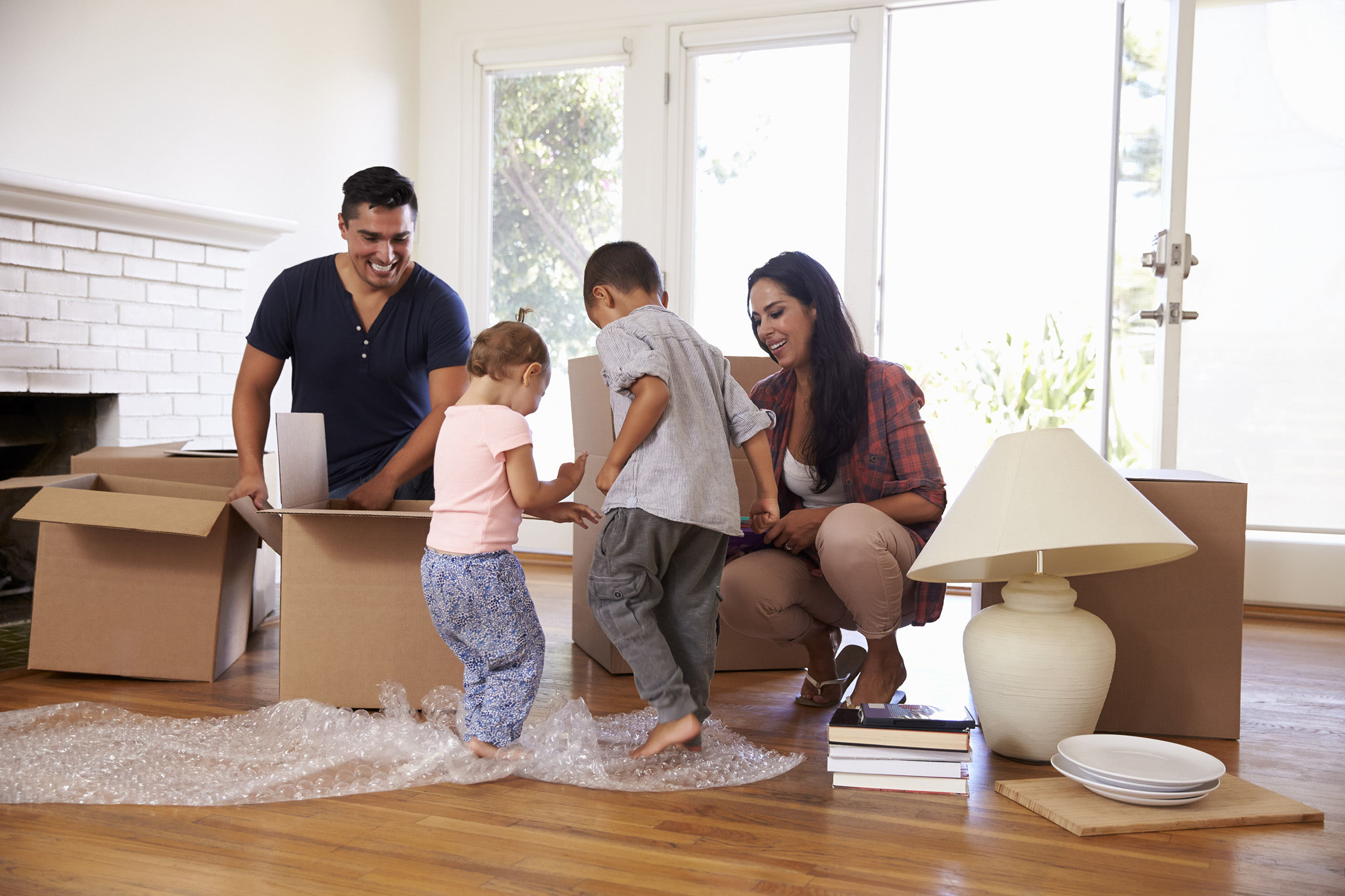 A family gathers around boxes in a new home.