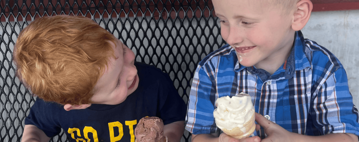 Scoops customers enjoy ice cream on a bench.