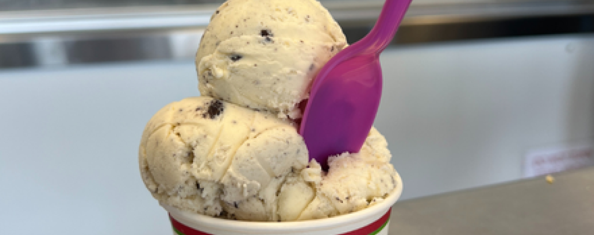 A spoon sits in a bowl of ice cream inside the Scoops Ice Cream Parlor.