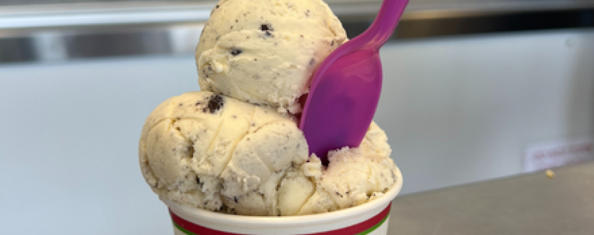 A spoon sits in a bowl of ice cream inside the Scoops Ice Cream Parlor.