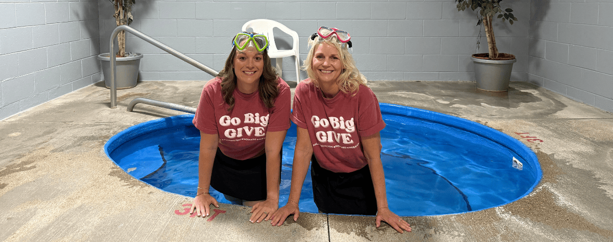 Greater Grand Island Community Foundation CEO Melissa DeLaet and Heartland United Way President Karen Rathke stand in a hot tub to promote Go Big GIVE.