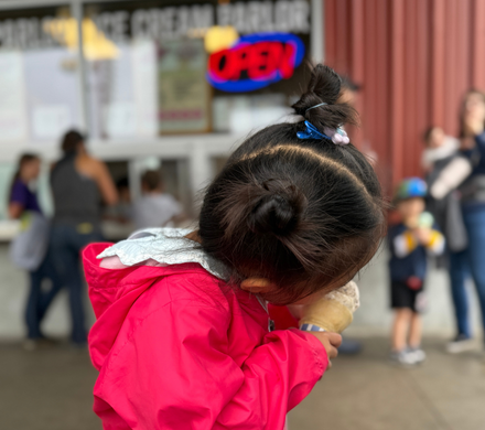 A young girl bites into her Scoops ice cream.