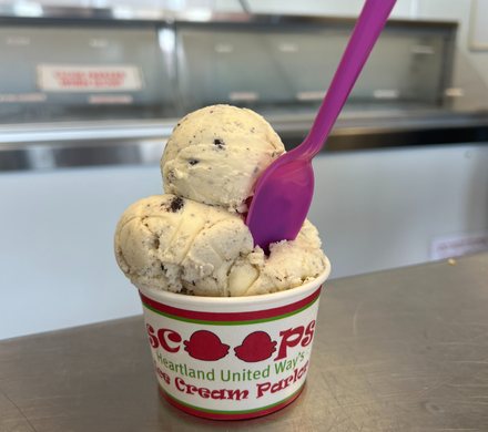 A spoon sits in a bowl of ice cream inside the Scoops Ice Cream Parlor.