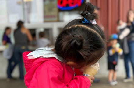 A young girl bites into her Scoops ice cream.