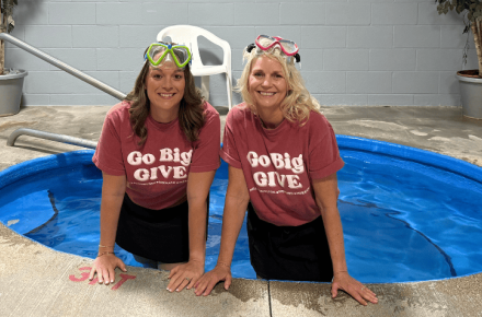 Greater Grand Island Community Foundation CEO Melissa DeLaet and Heartland United Way President Karen Rathke stand in a hot tub to promote Go Big GIVE.