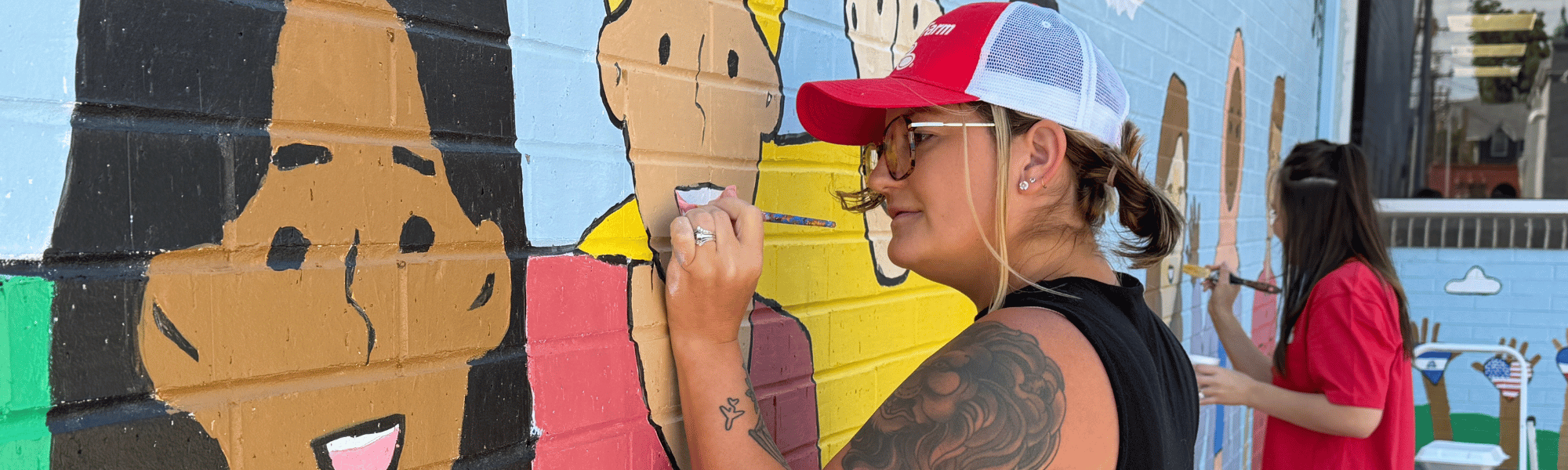 Staff from Lisa Willman State Farm retouch a mural at Literacy Council during Day of Action 2026.