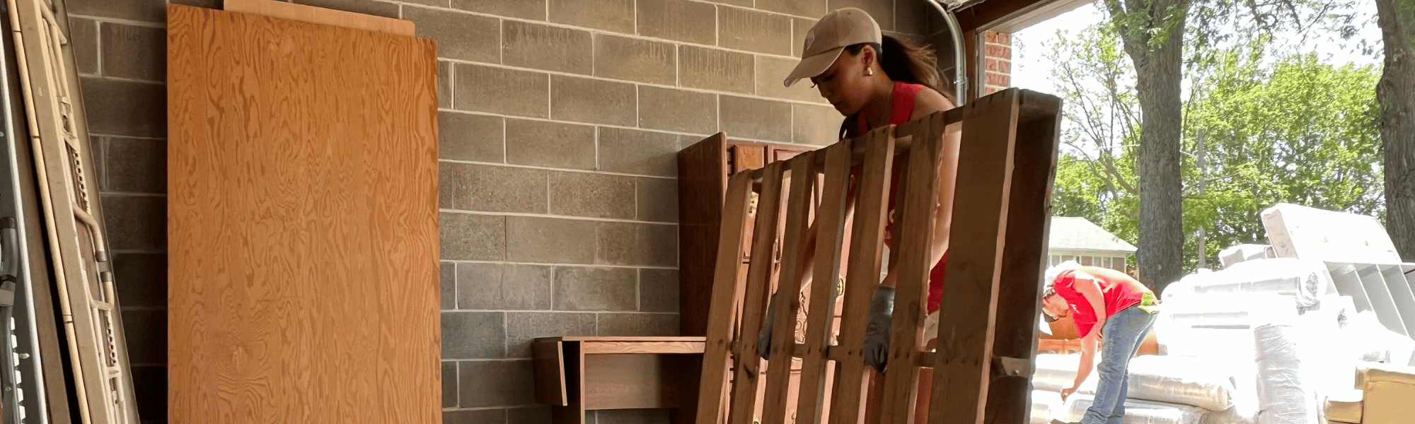 A Day of Action volunteer carries a pallet at Hope Harbor in 2025.