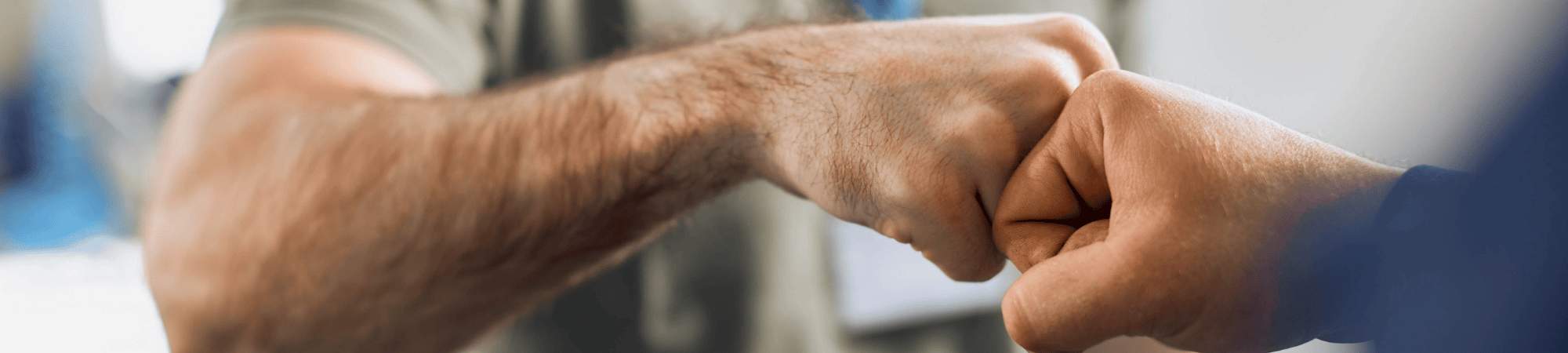 Two people are seen doing a fist bump.