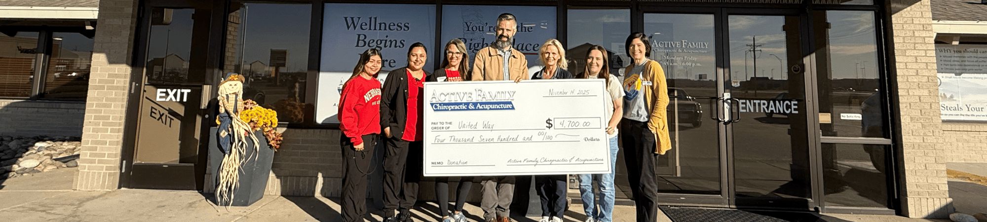Active Family Chiropractic and Acupuncture and Heartland United Way staff hold a giant check.