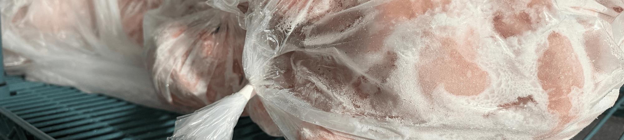 Frozen chicken sits in a freezer
