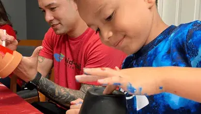 Volunteers paint flower pots at CNCAA during Day of Action 2025.