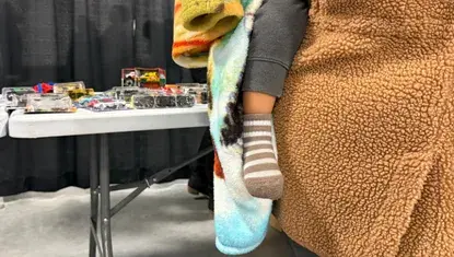 A parent holds her child during Heartland United Way's 2025 Holiday Toy Collection & Toys for Tots Distribution.