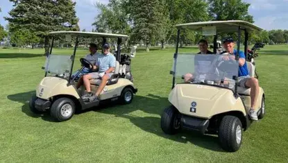 A team sits on two golf carts during Heartland United Way's 38th Annual Golf Tournament.